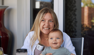 Mum wearing a hands-free breast pump while at a cafe.